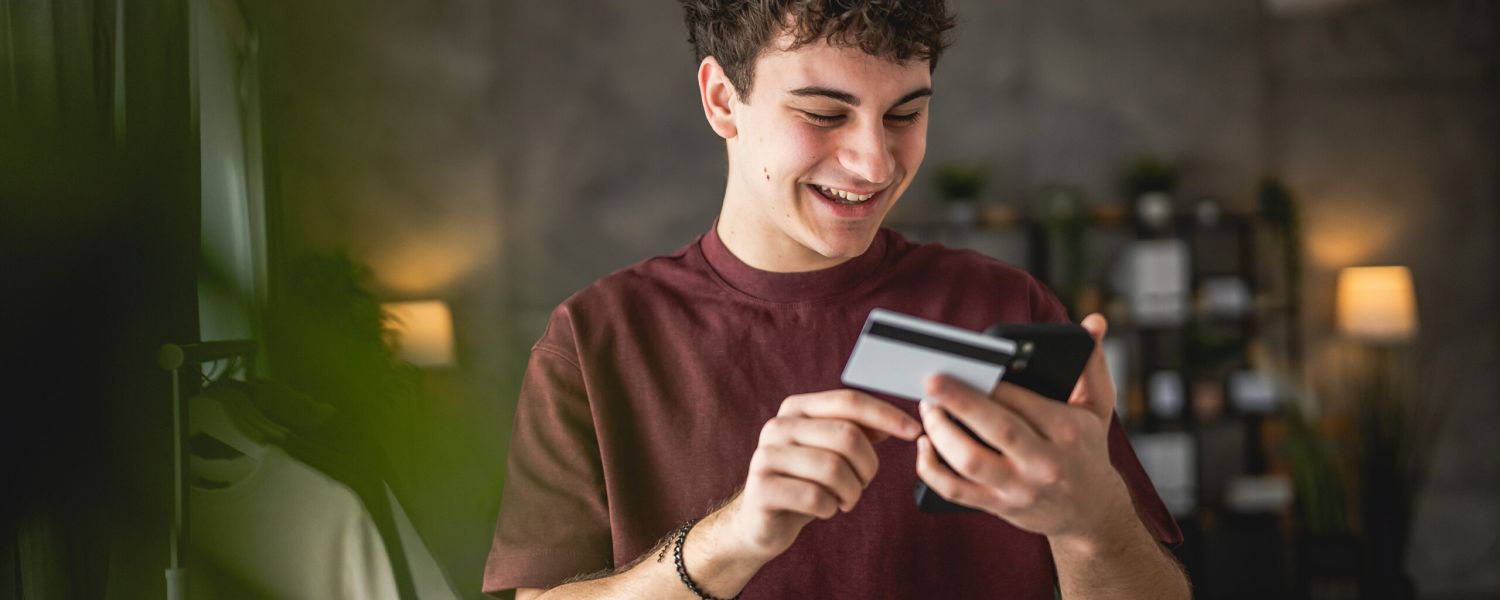 Chico joven mirando el móvil sonriente