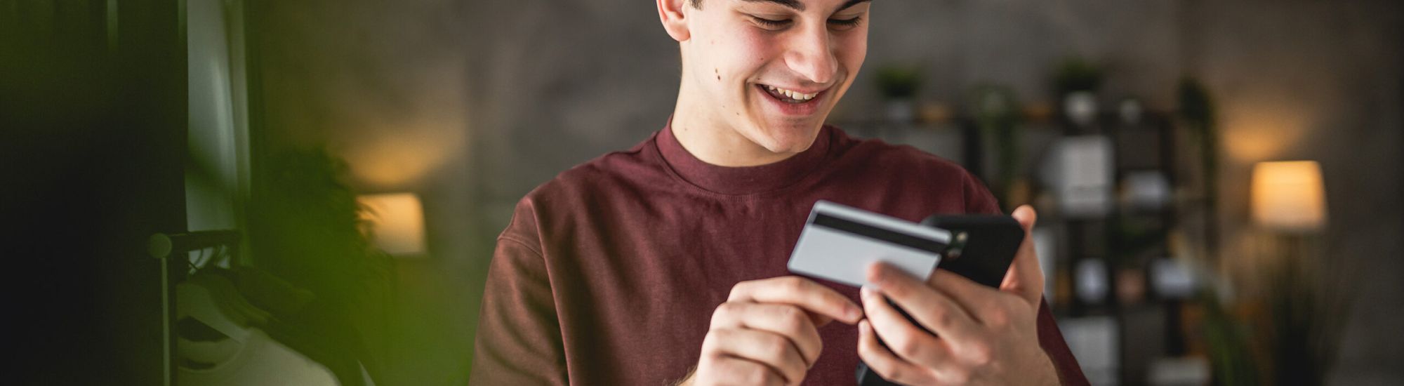 Chico joven mirando el móvil sonriente