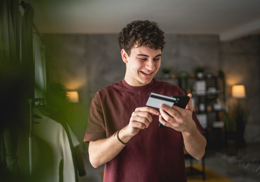 Joven mirando el móvil sonriendo 